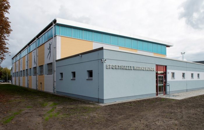 Sporthalleneingang mit gelben Wandplatten in Warnemünde