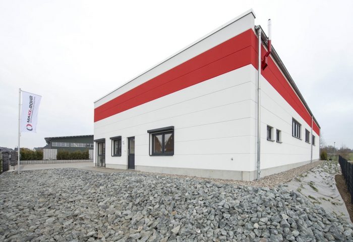 Seitenansicht Hallenbau Maxx-Rohr mit roten und weißen Wandplatten