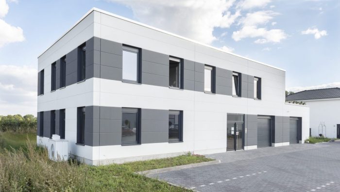 eletek Gewerbebau mit schwarzen und weißen Dachplatten