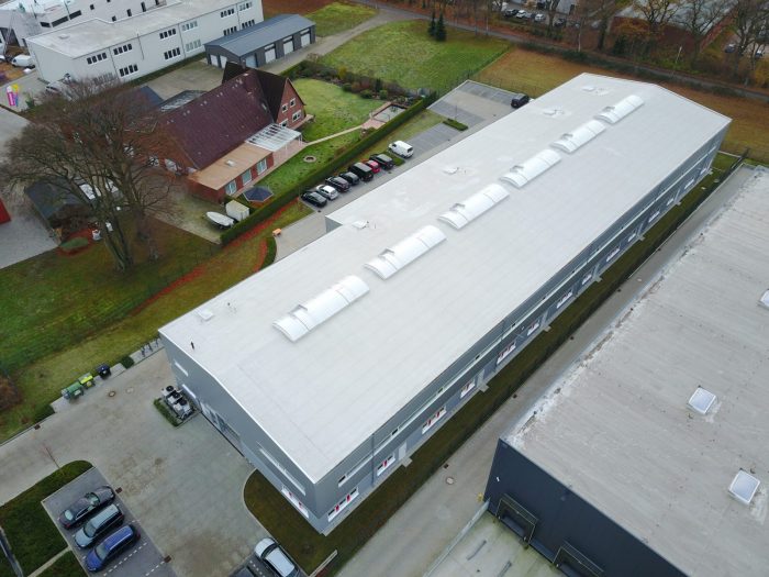 Vogelperspektive auf Hallenbau mit hellgrauen Dachplatten